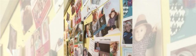 Eine Bilderwand mit Fotografien von kleinen Kindern.