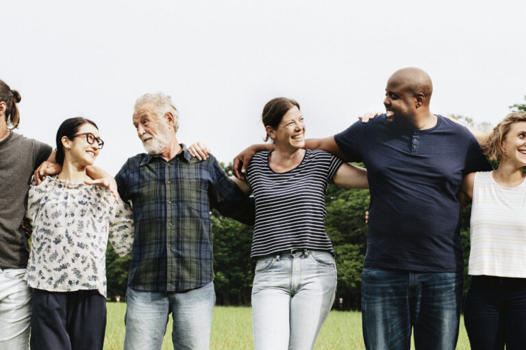 Eine Gruppe von Menschen umarmen sich im Park