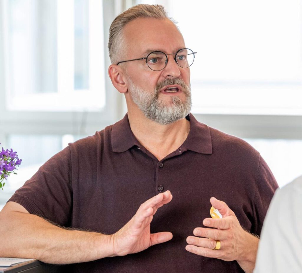 Foto von Ralf Kaufmann (Chiropraktiker) im Gespräch mit einem Patienten.